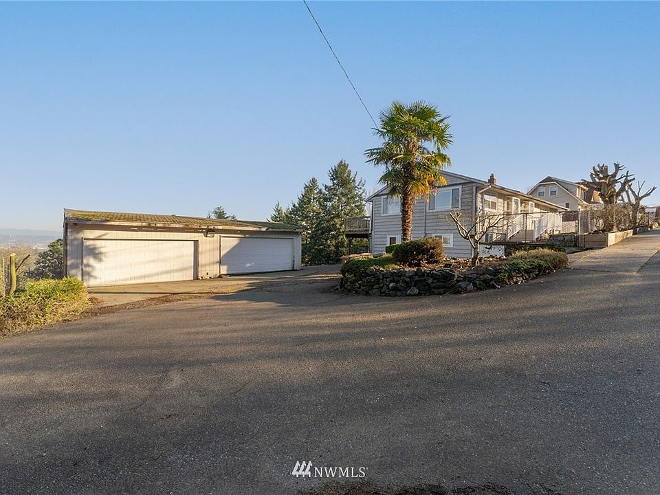 Beautifully nestled on the hillside, this elevated position offers this daylight basement rambler and detached 4 car garage/shop open sweeping views. A circular driveway with 3 points of access ensure ample parking and easy access.