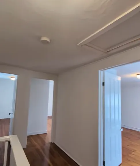 View of three bedroom entrances from top of stairs.
