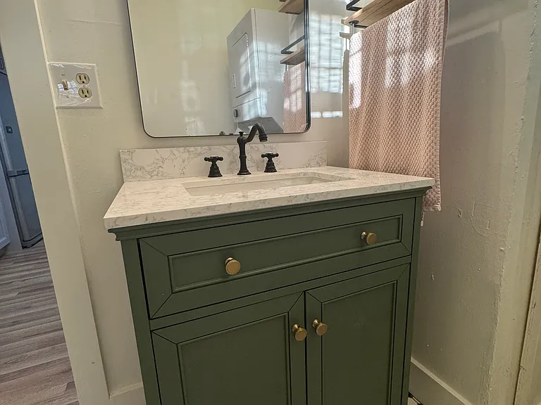 Remodeled bathroom with New super cute vanity with marble top. New Lighting and new floor.