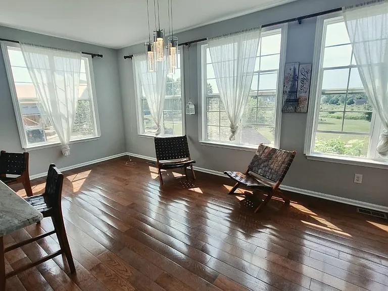 Surrounded by oversized windows, this inviting gathering space brings in abundant natural light while overlooking the peaceful backyard.