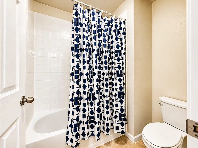 Shared upstairs bathroom with tub-and-shower combination. Shared with up to two other residents. Digitally enhanced for presentation.