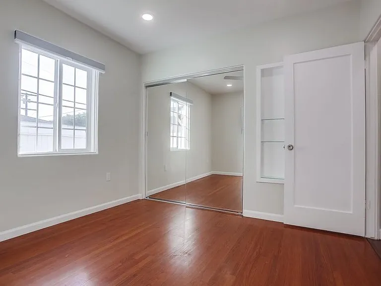 Hardwood floors and mirrored closet doors.