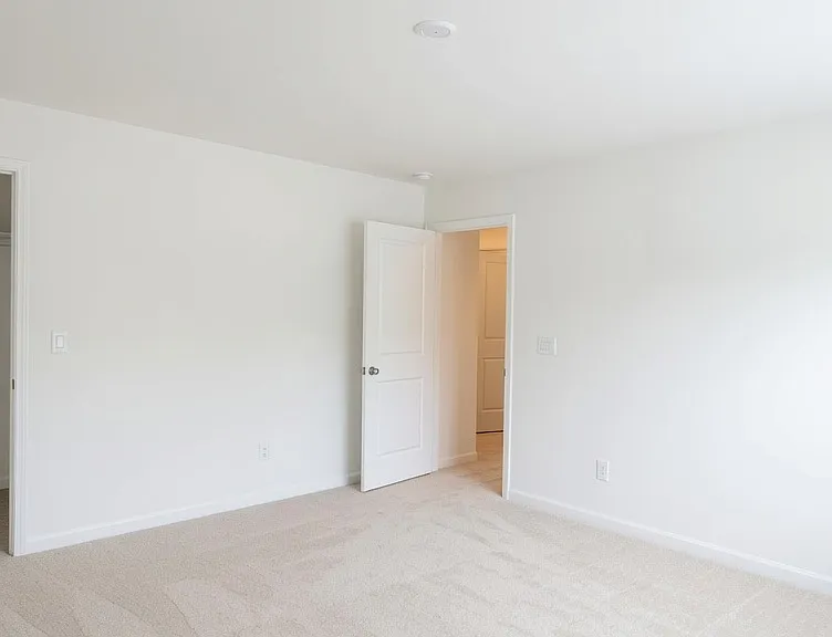 Another well-sized carpeted bedroom with closet access and soft lighting. Neutral finishes throughout make it easy to personalize.
