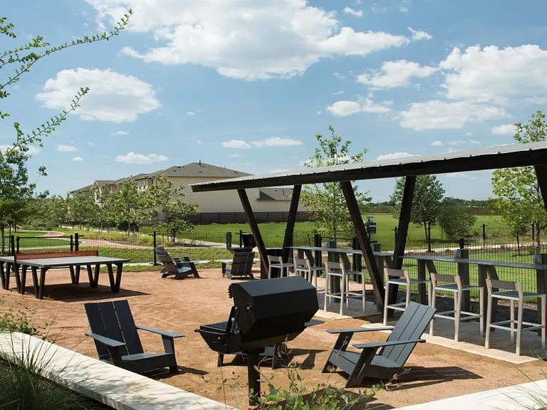 Community recreation area with BBQ pit, ping pong table, and fenced dog park