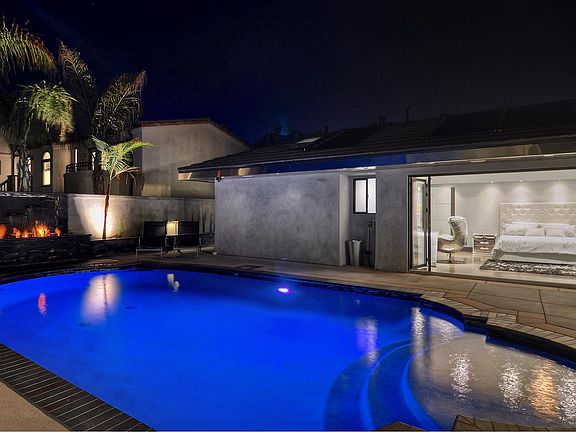 Enjoy pool and fireplace views from the master bedroom.