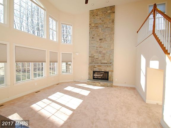 Two story family room w/ stone FP, power shades