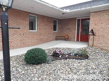 Front door with lamppost. : Driveway is next to ramp that leads to front door.