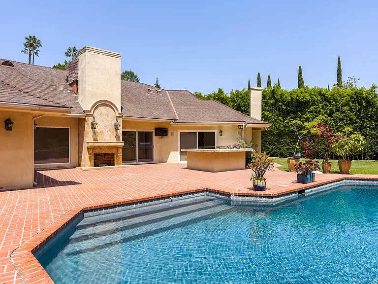 Pool steps and an adjacent outdoor kitchen make entertaining effortless at this Beverly Hills luxury rental, 1094 Garden Lane, 90210.