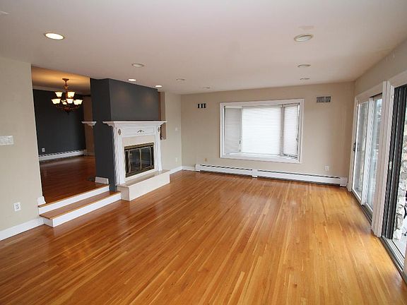 Sunken living room with double glass doors to large balcony w/NYC views, fireplace, very sunny, hardwood floors, hi hat lighting