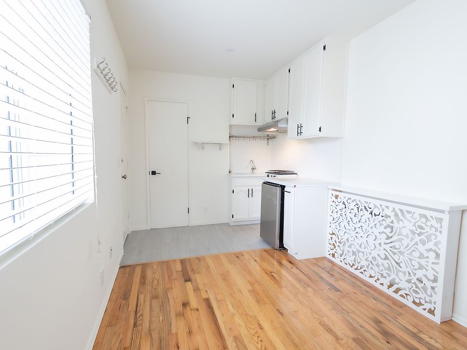 Kitchen has a brand new fridge, with a sink and two burner stove.