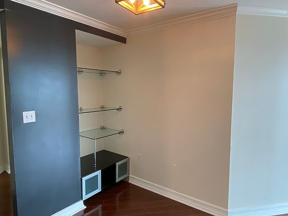 Dining room or mix use space with glass shelving and cabinets. New paint and lighting.