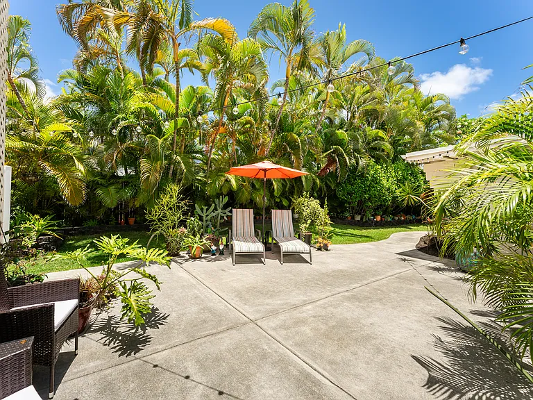 Private outdoor patio surrounded by lush tropical landscaping, creating a peaceful setting for relaxing or entertaining.