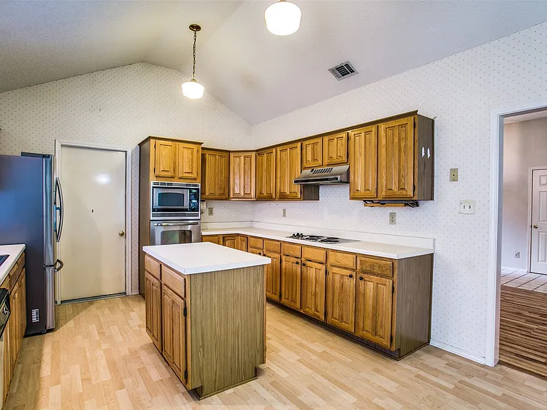 A close up of the kitchen area. Fully equipped with microwave, oven and fridge that stays. All stainless steel. And an abundance of cabinetry.