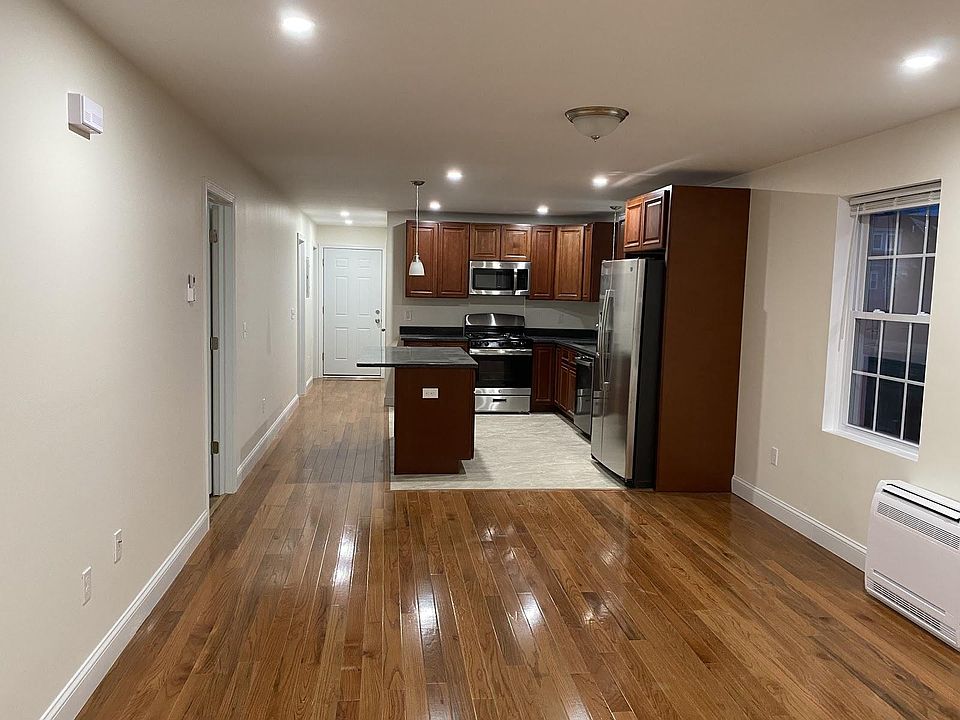 Kitchen and living room; bedroom doors are along left wall, facing back door of apartment.