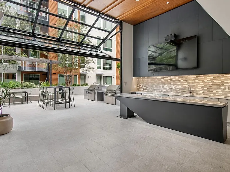 Outside lounge with common area seating, barbecue grills, and entertaining kitchen