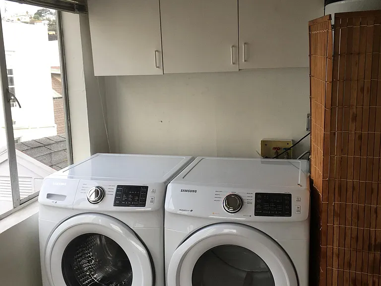 New frontloading washer and drier in laundry room; hanging b