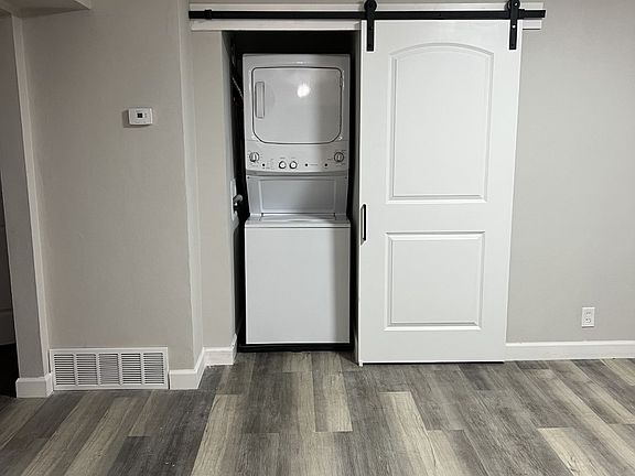 Standing in the dining room looking at the in-unit laundry and hallway.