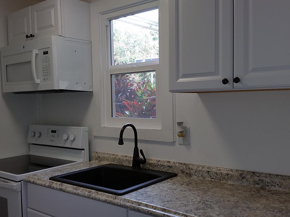 Kitchen with microwave oven, glass top stove, and granite sink