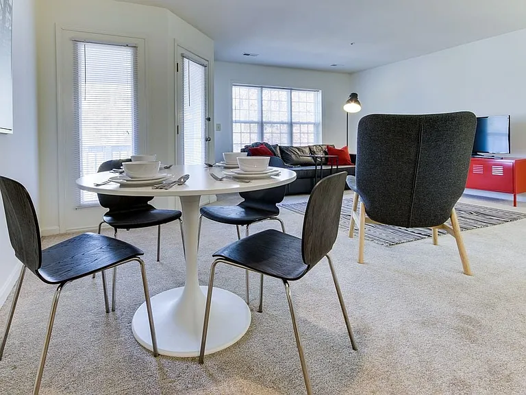 Carpeted living and dining area with balcony access