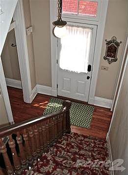 Beautiful entry hall with gorgeous, pattern carpet and hardwood floors.