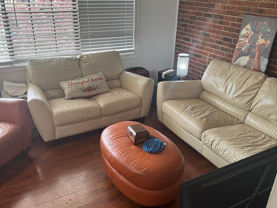 Living room with natural light and historic exposed brick wall