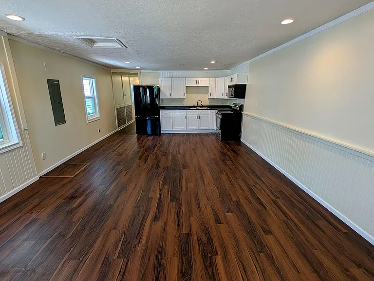 Open-concept living and kitchen area with new flooring, recessed lighting, and bright natural light_perfect for entertaining or relaxing.