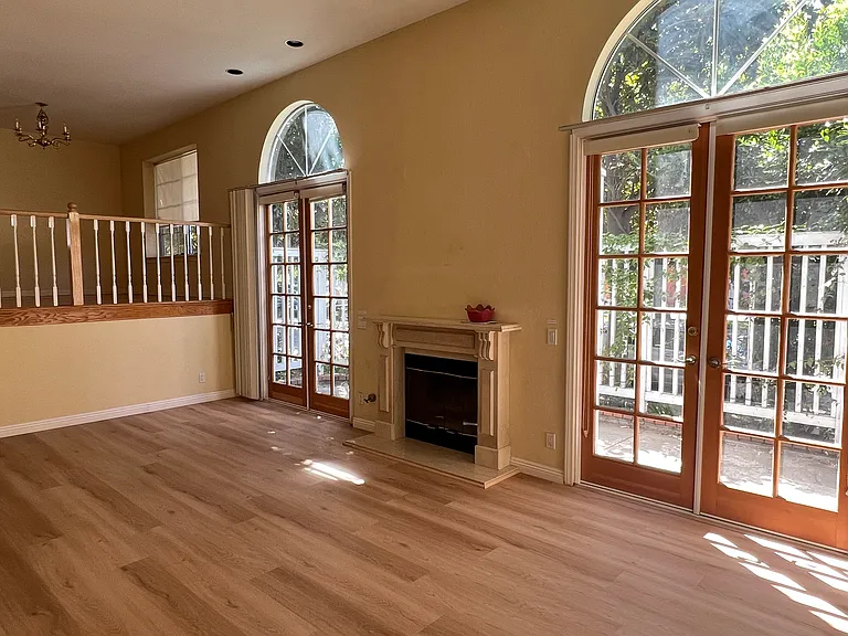 Living room with fireplace, and double French door to patio