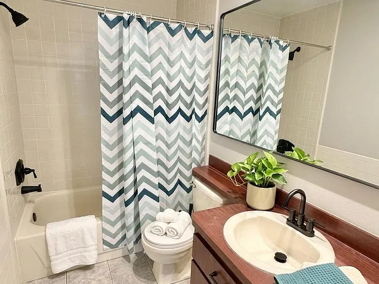 Full bath with tub/shower combo, wide vanity with storage, and a large mirror for everyday convenience.