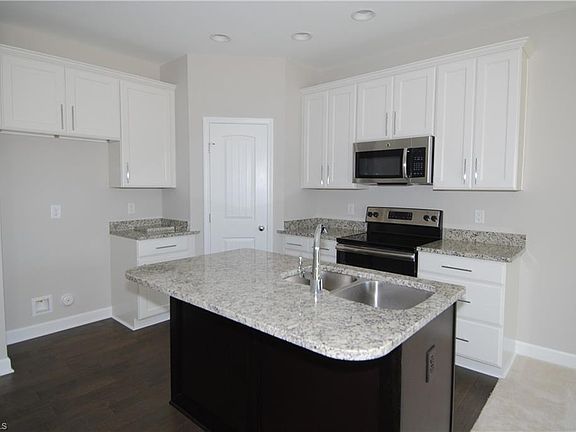 Bright, beautifully designed kitchen with stainless appliances, granite counters, and an island (refrigerator included; not shown).