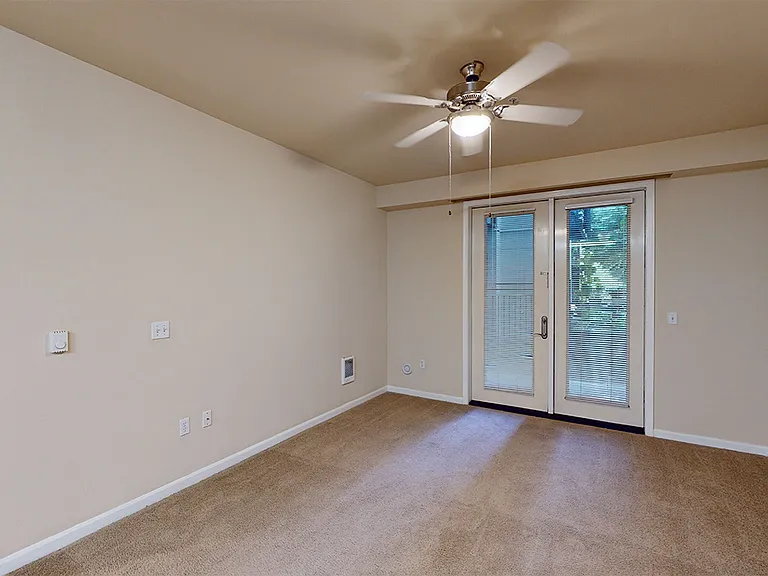 Apartment living room with plush carpet flooring.