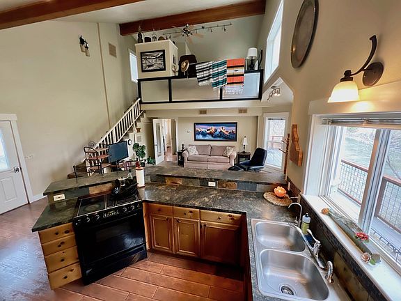 View from corner of kitchen. Open floorplan with on ground level with loft above