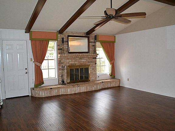 Family room with vaulted ceilings and brick fireplace.