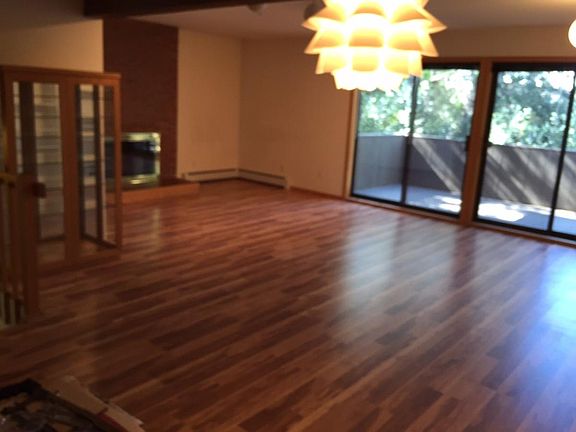 Main level, living room with fireplace, balcony and dining area.