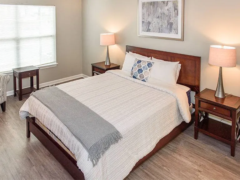 Spacious bedroom with large, bright windows and plank flooring