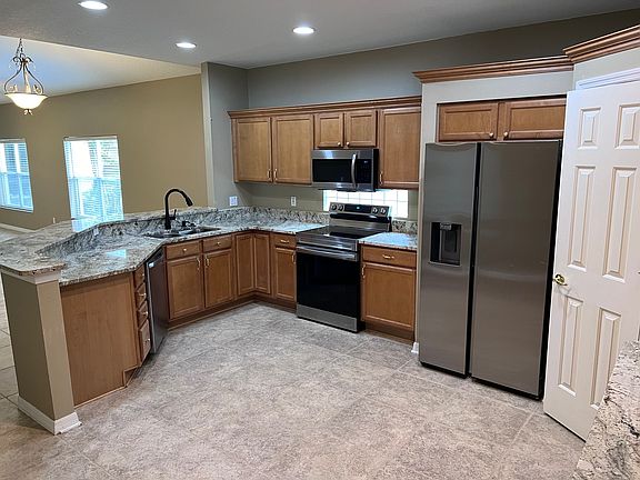 Open kitchen with new stainless steel appliances. Large pantry.