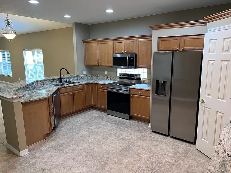 Open kitchen with new stainless steel appliances. Large pantry.