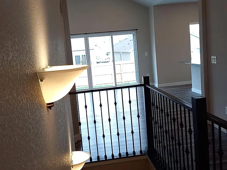 Sconce lighting at stairway, ground floor slider in the background.