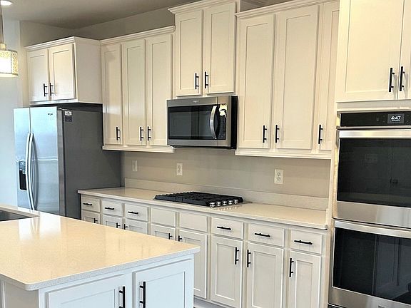 Island kitchen with white cabinets in a DRB Homes Harlow II plan at the Laurel Overlook community.
