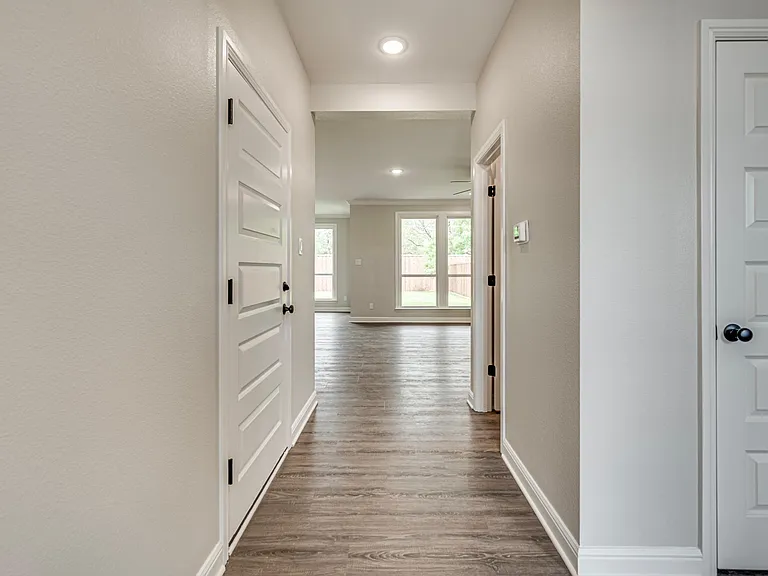 View of hallway as to enter, left door is to the garage, right door is your coat closet, and back door is to half bath