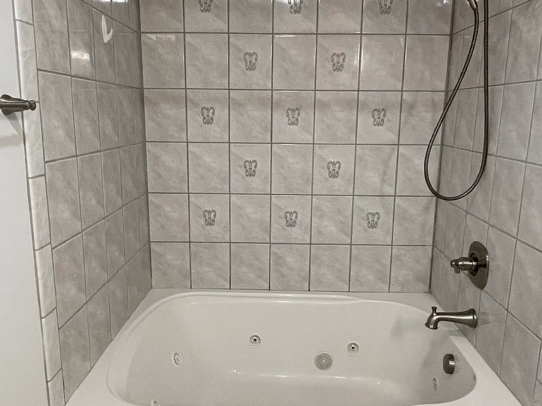 Extra large jacuzzi bathtub with tiled shower.