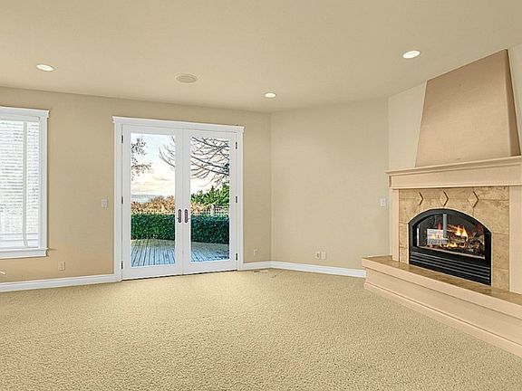 Living room with French doors to deck, sideyard and sound views.