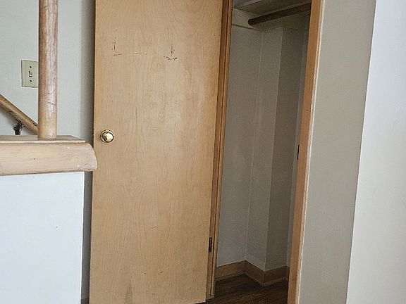 Coat closet at bottom of stairwell leading to the upstairs bedrooms.