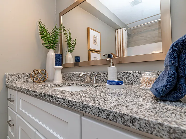 Bright bathroom with granite counters and modern cabinetry