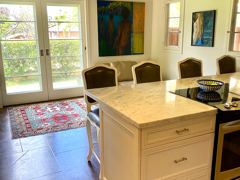 Open kitchen with bright lighting and a wall mounted split air conditioning unit.