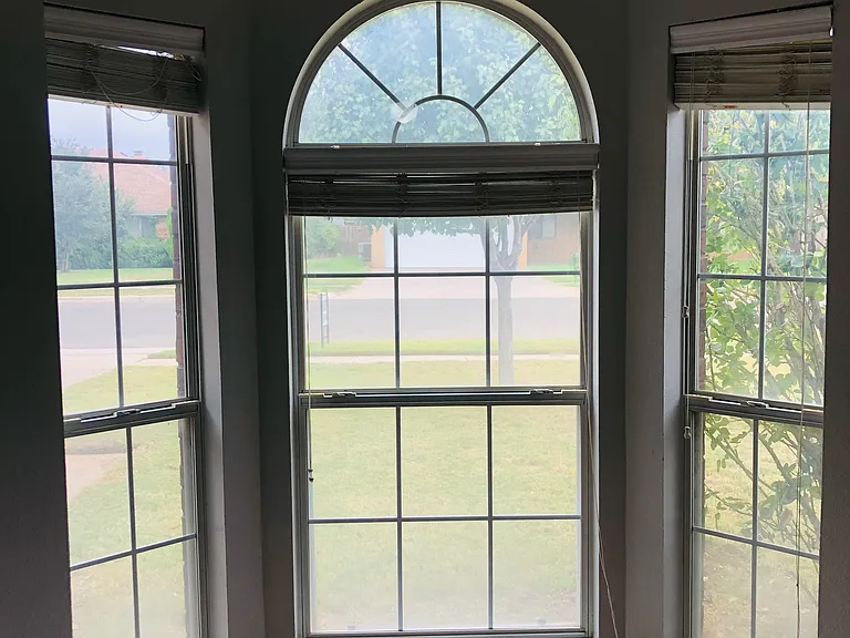 Guest bedroom with gorgeous floor-to-ceiling windows. Great reading nook or space with natural light.