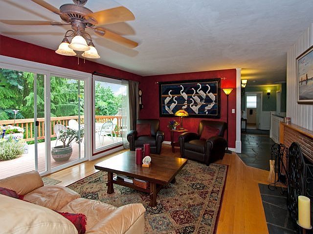 Living room with glass slider leading to low maintenance deck with view