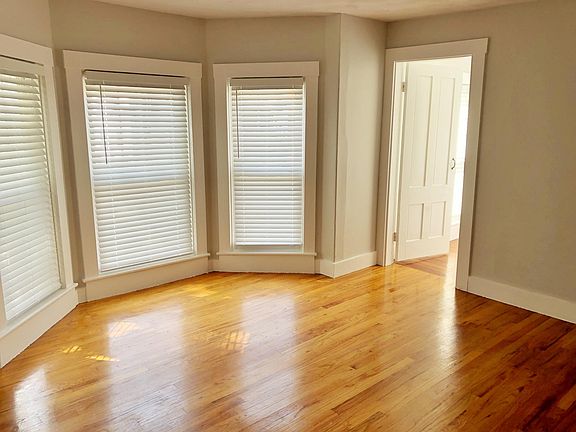 Hardwood first bedroom with bay window and walk-in closet.