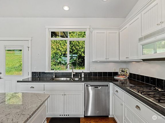 Modern kitchen with dishwasher, electric oven, microwave.