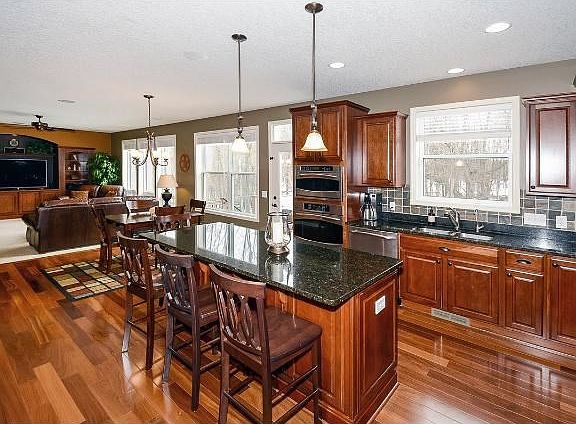 Brazilian Teak wood floors showcase this spacious kitchen boasting cherry cabinets, granite counters and SS appliances.