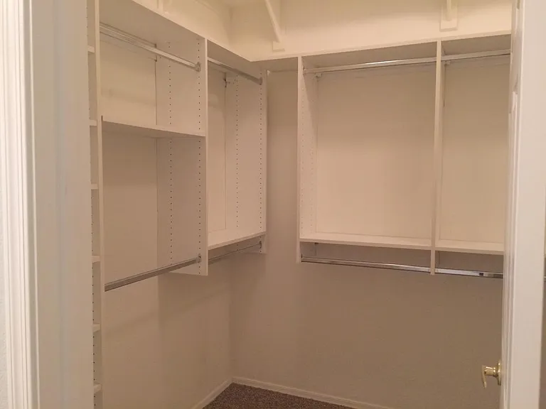 The large master bedroom closet features custom shelving.